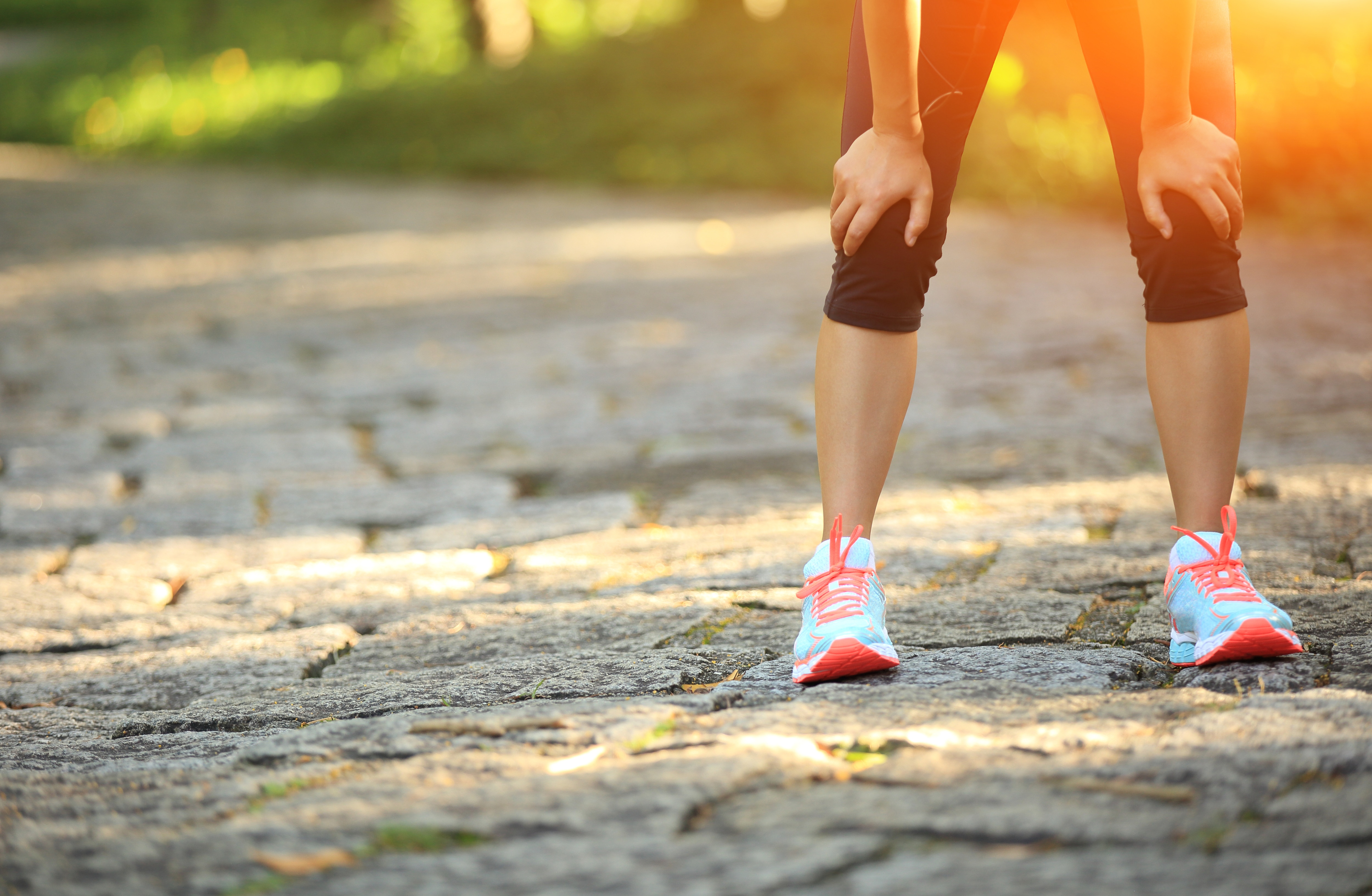 Woman resting on her knees after a recovery run